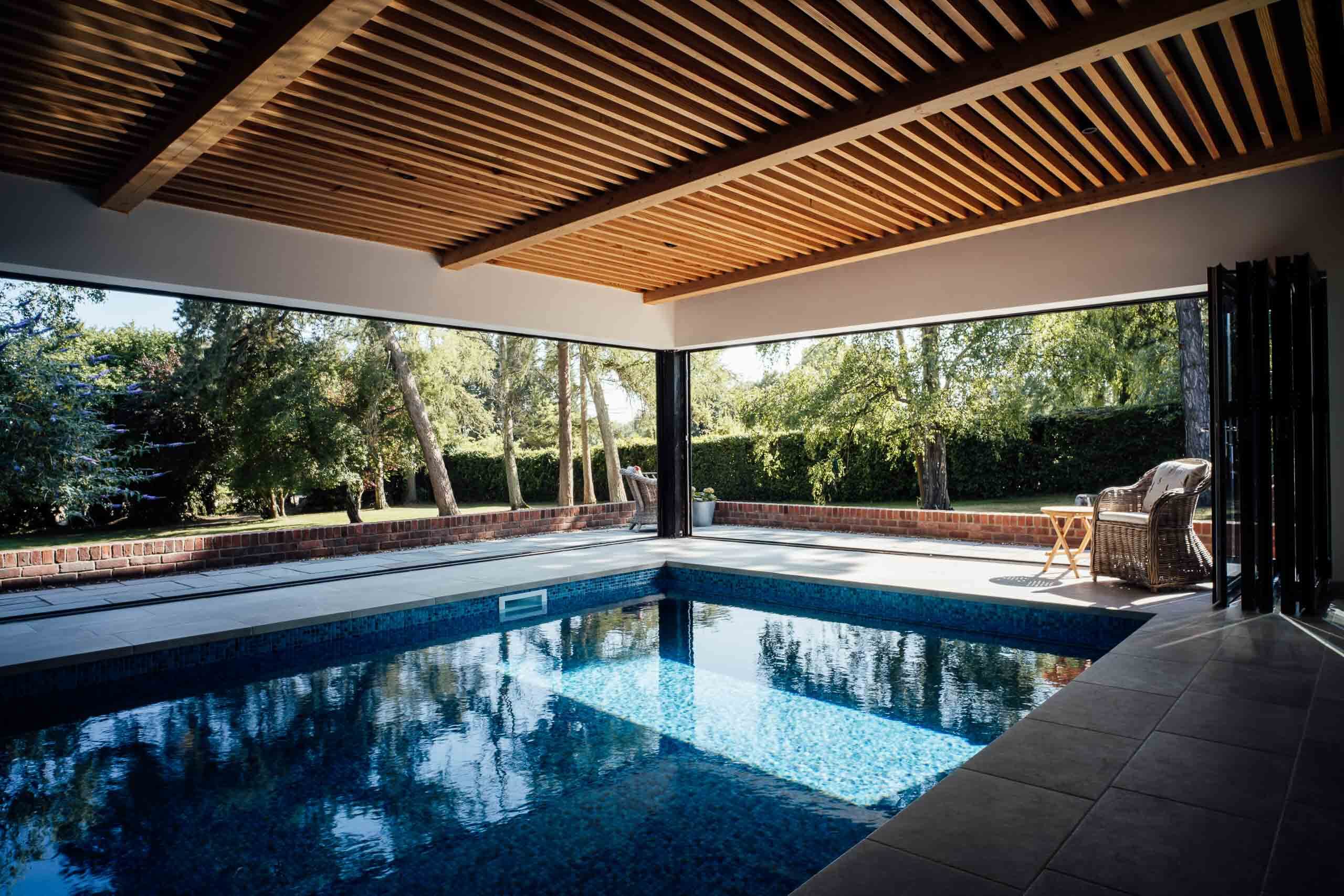 Contemporary swimming pool extension with timber cladding and garden views in Buckinghamshire